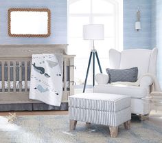 a baby's room with blue walls and white furniture