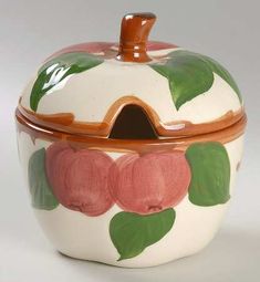 an apple shaped container with leaves painted on it