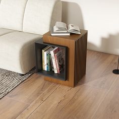 a book shelf sitting on top of a wooden floor next to a white couch