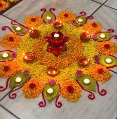 a decorated floor with candles and flowers in the shape of a flower on top of it