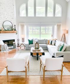 a living room filled with furniture and a fire place in front of a large window