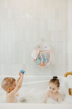 two babies playing in a bathtub with soap