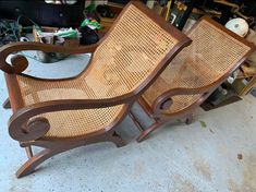 two wooden chairs sitting next to each other on top of a cement floor in a garage