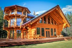 a large log home with lots of windows and wood trimmings on the front