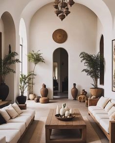 a living room filled with furniture and potted plants