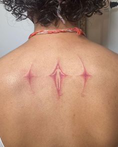 the back of a woman's neck with pink ink on it