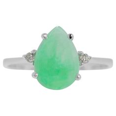 This exquisite 18K white gold ring features a stunning 1.33ct pear-shaped jade as its centrepiece, radiating a rich green hue that embodies elegance and tradition. Flanking the jade are two round brilliant diamonds with a total carat weight of 0.04ct, offering an I-J colour grade and SI clarity grade for a subtle sparkle. The ring has a total carat weight of 1.37ct and a jewellery weight of 1.91 grams, making it a delicate yet eye-catching piece. Sized at 54/15, this ring combines timeless beaut Jade Ring, Rich Green, Three Stone Rings, 1 Carat, Three Stone, Brilliant Colors, White Gold Rings, Pear Shaped, Round Brilliant