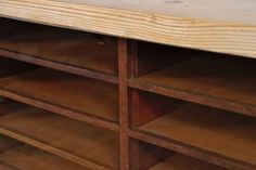 a wooden shelf with several shelves and drawers