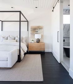 a bedroom with white walls and wood floors