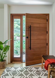 a large wooden door in the middle of a living room with a rug on the floor