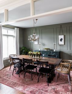 a dining room table with chairs and a chandelier hanging from it's ceiling