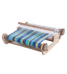 a blue and green striped loom on a wooden stand