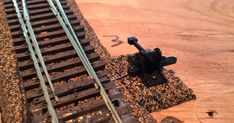 a close up of a train track on a wooden surface with the tracks marked out