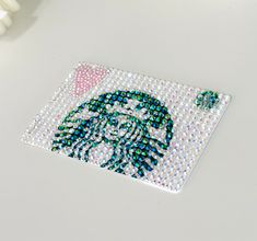 there is a beaded coaster with the image of a woman's face on it