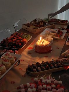 a table topped with lots of cakes and cupcakes