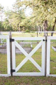 a white gate is open on the grass