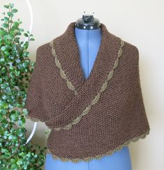 a knitted brown shawl sitting on top of a blue mannequin