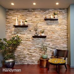 a living room filled with lots of furniture and plants on top of wooden shelves in front of a stone wall