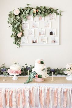 a table topped with cakes and desserts on top of a wooden table covered in greenery