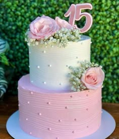 a pink and white cake with flowers on top