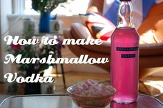 a pink bottle sitting on top of a table next to a bowl of marshmallows