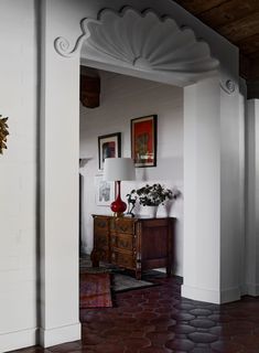 an archway leading into a living room with pictures on the wall and a table in front of it