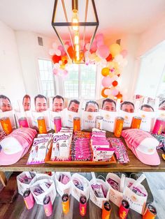 a group of people sitting at a table with pink and orange decorations on top of it