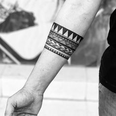 two people holding hands with tattoos on their arms and wristbands, one is wearing a bracelet