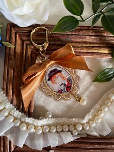 a keychain with an image of a woman in a hat and pearls on it