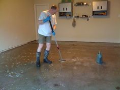 a man is cleaning the floor with a mop in his hand and wearing rubber boots