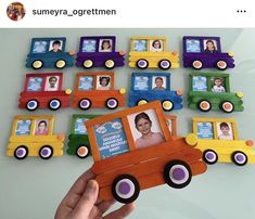 a person holding up a wooden toy truck with pictures on the front and back of it