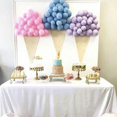 an ice cream cone dessert table with cake and balloons