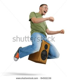 a man is jumping in the air with his legs spread out and holding a speaker