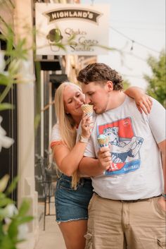 a man and woman sharing an ice cream cone