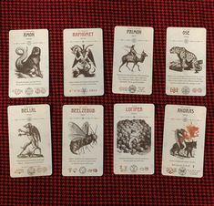 four cards with different animals on them sitting next to each other in front of a red table cloth