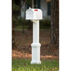 a white mailbox sitting in the grass next to a tree