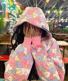 a woman covering her face while sitting at a table