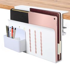 a white desk organizer with pens and pencils in it