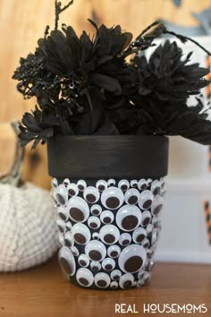 a potted plant sitting on top of a wooden table next to a white pumpkin