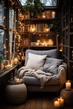 a room filled with lots of books and candles on the windowsill, all covered in blankets