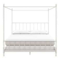 a white bed frame with four posts and pillows on top of the headboard, in front of a white background