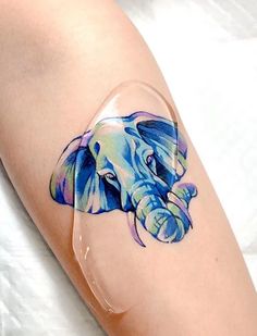 an elephant tattoo on the leg of a woman's arm with clear plastic coverings