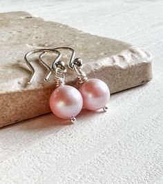 Swarovski Crystal Pearls in ethereal Blush Pink are wrapped in shiny sterling silver and suspended from hook style ear wires. Lightweight and perfect for the most lovely bridesmaids gifts or daily wear to add a touch of color to your office attire. * Pearl: Swarovski 8mm in Blush Pink, as shown More colors available! * Metal: .925 Sterling silver * Length: About 1 inch from top of the ear wire Brides needing multiples for your besties? Multiple order discounts: 3-5 pairs receive 10% off 6+ pairs Pink Sterling Silver Pearl Earrings For Pierced Ears, Pink Sterling Silver Drop Pearl Earrings, Minimalist Hypoallergenic Pink Jewelry, Elegant Pink Earrings For Everyday Wear, Pink Elegant Everyday Earrings, Elegant Pink Everyday Earrings, Hypoallergenic Pink Pearl Earrings As Gift, Hypoallergenic Pink Pearl Earrings For Gift, Pink Everyday Jewelry With Ear Wire