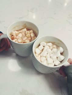 two cups of hot chocolate with marshmallows in them