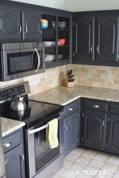 a kitchen with black cabinets and granite counter tops