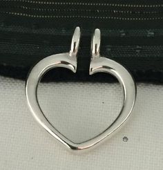 A unique way to wear a ring as a pendant with this sterling silver heart-shaped ring keeper pendant. Open at the top of the tapered heart design, with twin closed ring bails, this pendant is ideal for use with any style of ring; simply slide your ring onto the keeper and then string the pendant on chain or cord (up to 3mm dia.), holding the ring in place and creating a secure connection for your treasured ring.Specifications:Jewelry Type : PendantsMetal type : Sterling silverKarat/purity : 925Di Nickel Free Elegant Heart Ring, Elegant Nickel-free Heart Ring, Sterling Silver Open Heart Ring, Silver Heart Charm Ring For Valentine's Day, Silver Heart Ring With Charm For Valentine's Day, Sterling Silver Double Heart Ring With Charm, Sterling Silver Open Heart Charms Jewelry, Nickel-free Open Heart White Gold Jewelry, Ring Holder Pendant