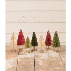 small christmas trees are lined up on a wooden table