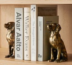 two bookends with dog figurines next to each other on a shelf