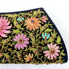 an embroidered black purse with pink flowers on it