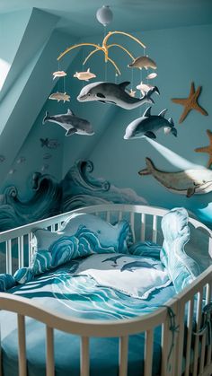 a baby crib with sea animals hanging from the ceiling